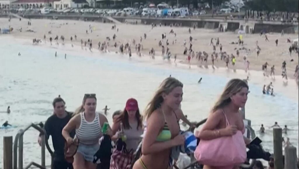 A beach scene with people enjoying sun and sand during daytime.