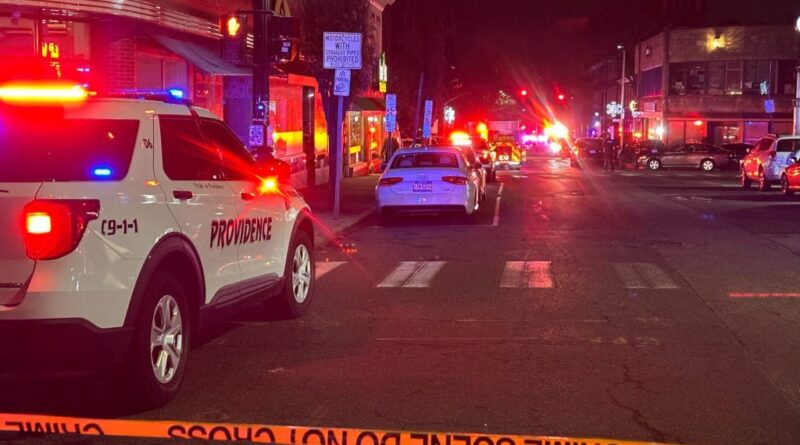 Police car and crime scene tape at night in an urban area.