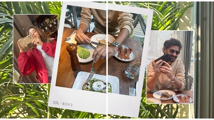 A woman taking a selfie at a cafe with friends, enjoying food and drinks in a lively setting.