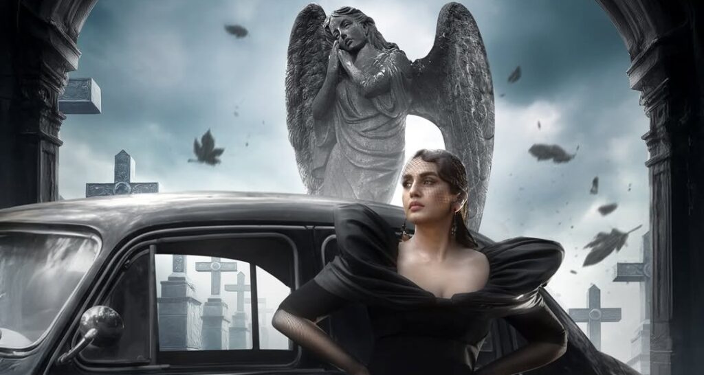 A woman in a black dress standing beside a vintage car with a large angel statue in the background.