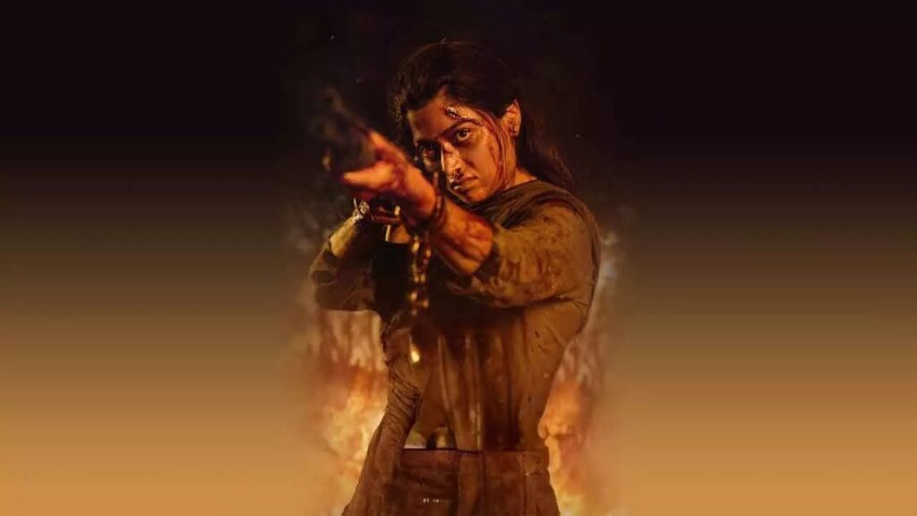 A woman in traditional attire performing a dramatic pose with fire in the background.