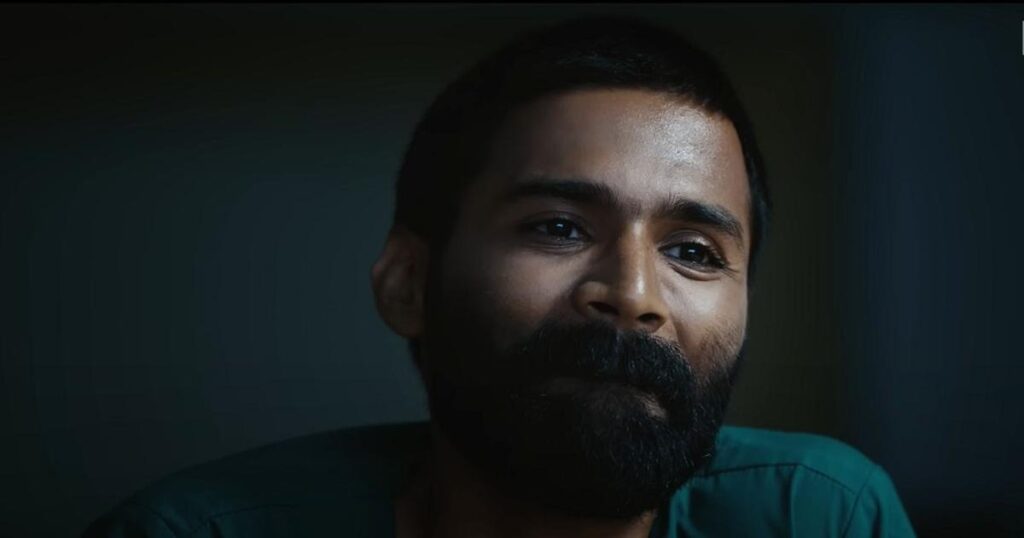 A man with a beard and short hair, looking thoughtfully into the distance.