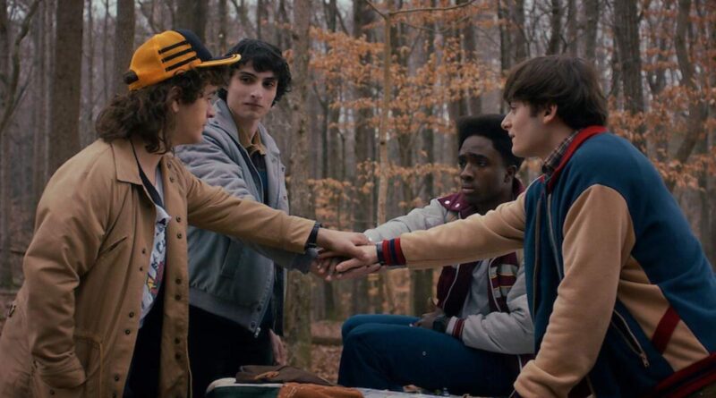 Empathetic group handshake in forest setting promoting unity and friendship.