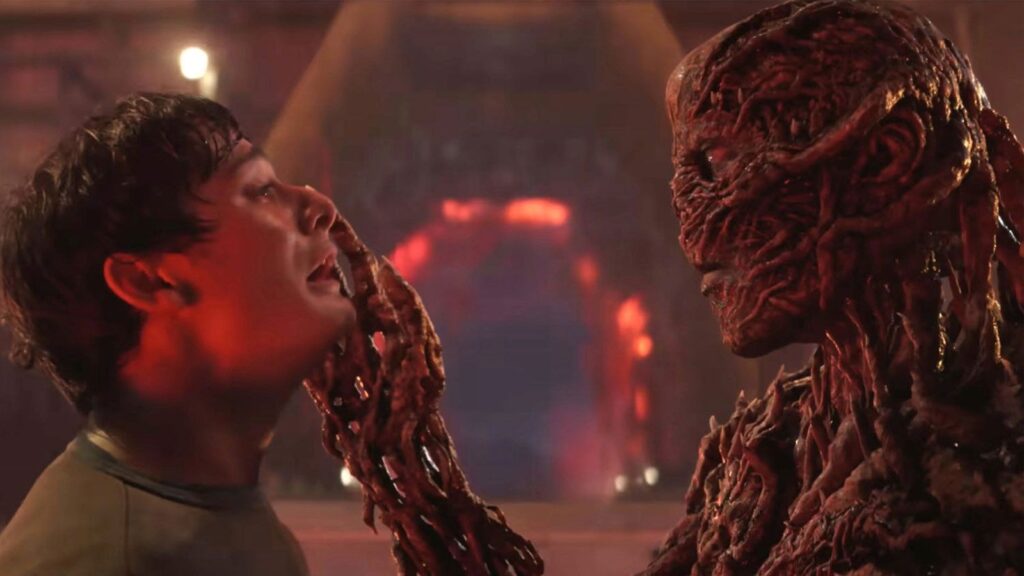 A young woman facing a monstrous creature with exposed brain and twisted features.