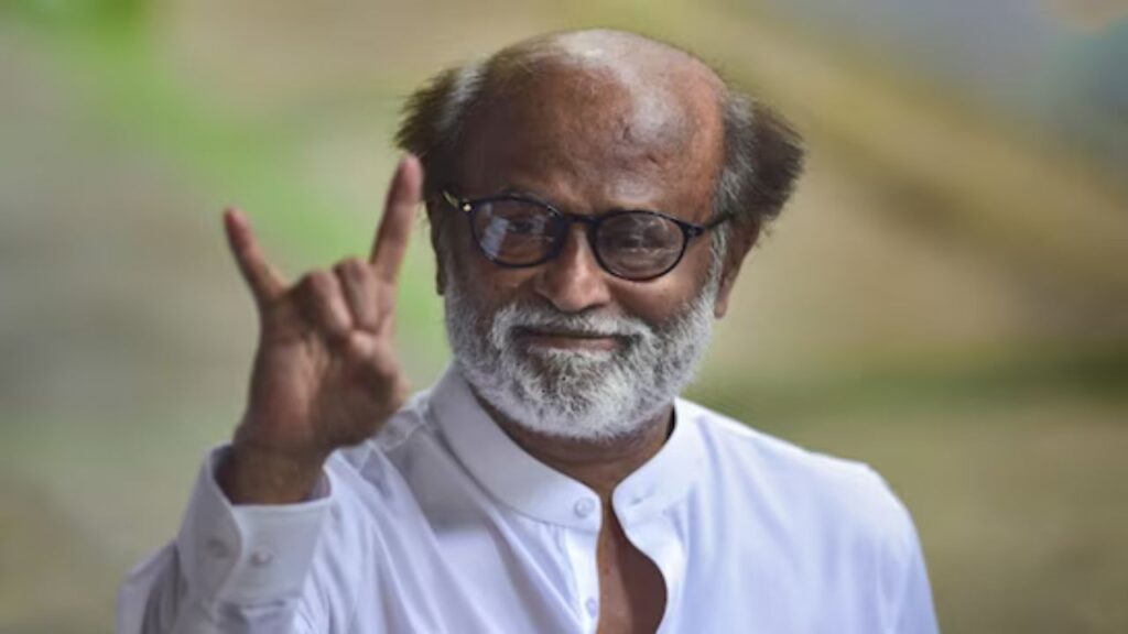 A man with glasses and a white shirt making a hand gesture outdoors.