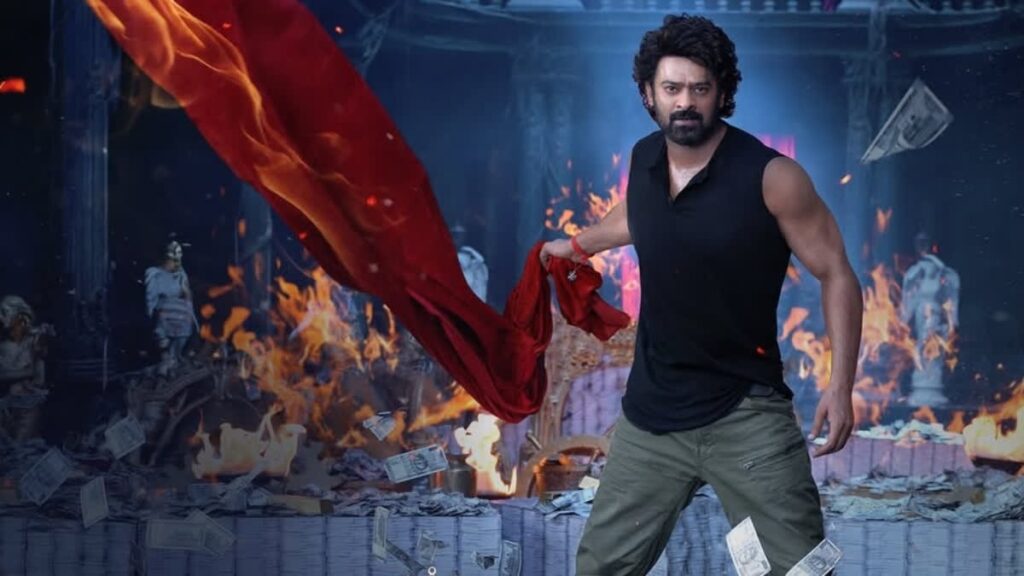 A man with curly hair and a beard standing confidently in a fiery, chaotic scene with flames and deb.