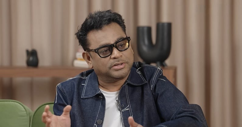 A man speaking during an interview or discussion in a professional setting.
