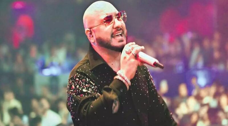Male singer performing on stage at a concert with a microphone in hand.