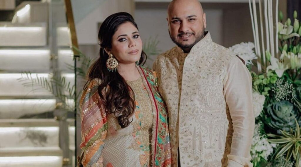 Elegant Indian couple in traditional attire celebrating a special occasion at home.