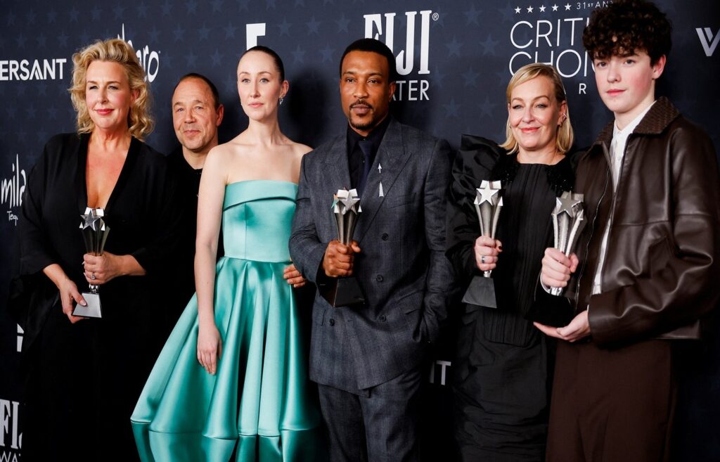 Elegant group of award winners at a formal event, holding trophies and celebrating success.