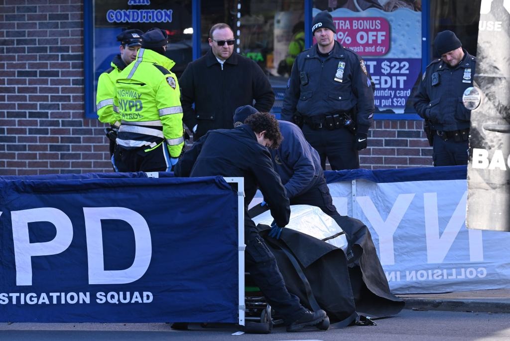 Police investigation scene with officers and forensic team on the street.
