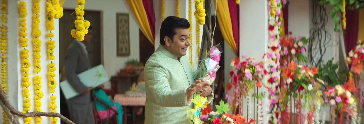 A man celebrating a traditional Indian festival with flowers and decorations.
