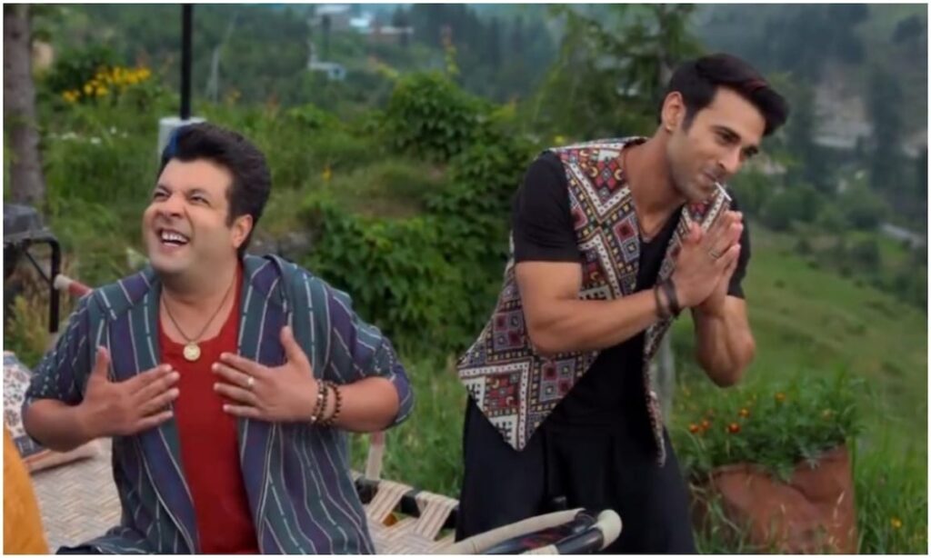 A man and a boy performing a traditional Indian ritual outdoors, surrounded by greenery.