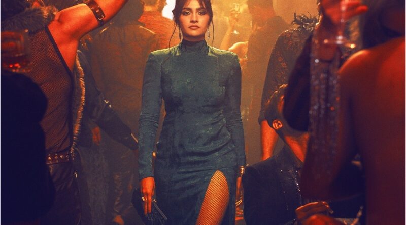 Elegant woman in a teal dress with a high slit at a lively party scene.
