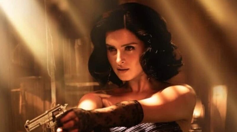 Seductive woman with a gun, dark hair, intense expression, in a dramatic, cinematic setting.