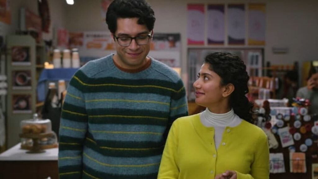 A woman and a man having a conversation in a bookstore or library setting.